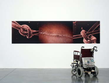 Wheel chair sculpture and in front of photograph