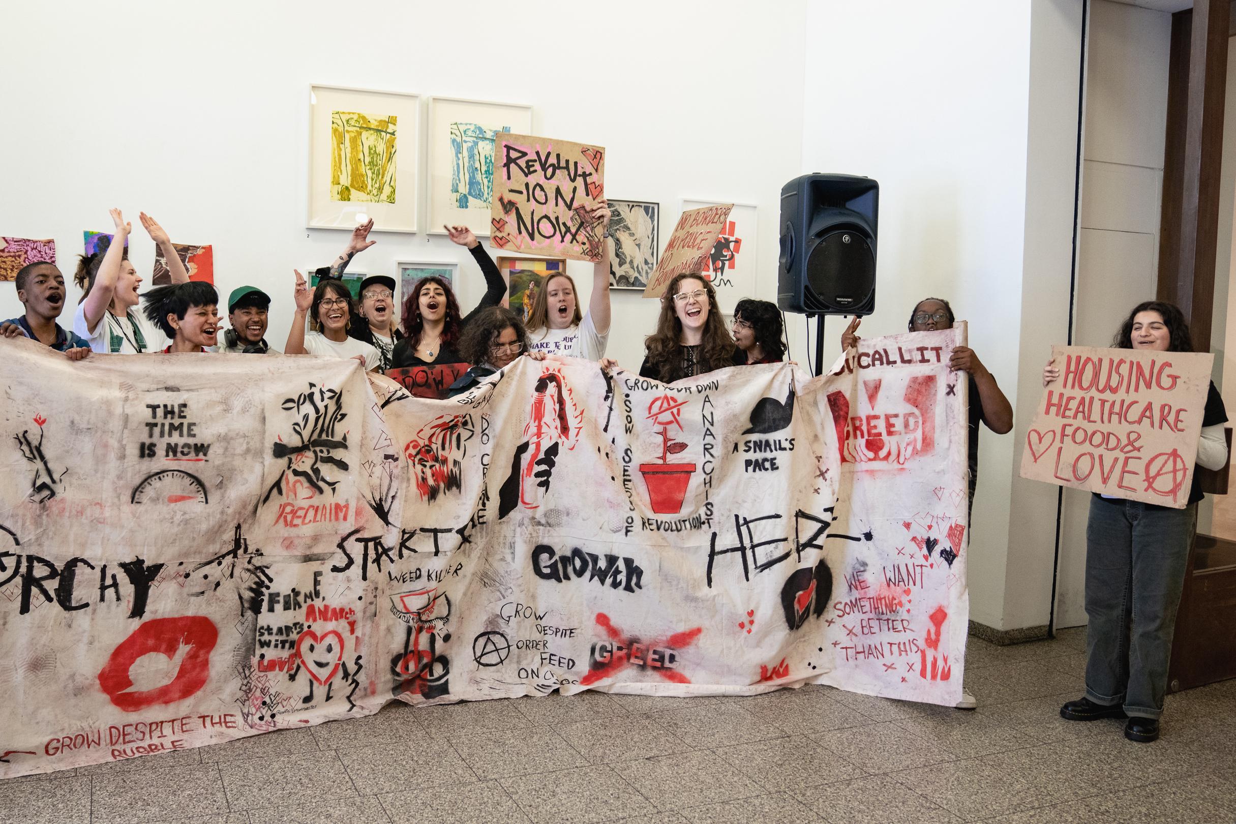 Group of young people in a row with their arms raised exclaiming. They